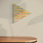 Triangular abstract composition of bright, horizontal pastel streaks on a neutral wall.
