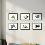 Abstract acrylic composition featuring geometric triangles in grey, blue, and black within a black frame.