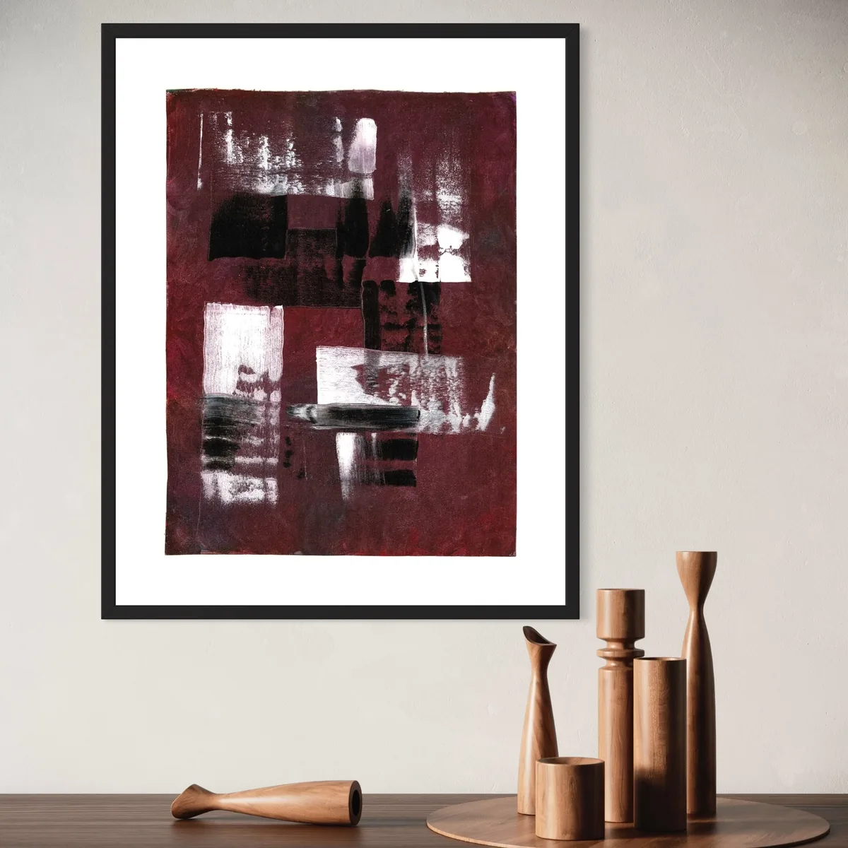 Abstract acrylic work in deep reds and browns, framed on a light wall.