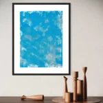 Vibrant blue and gold abstract acrylic artwork in a black frame against a light wall.