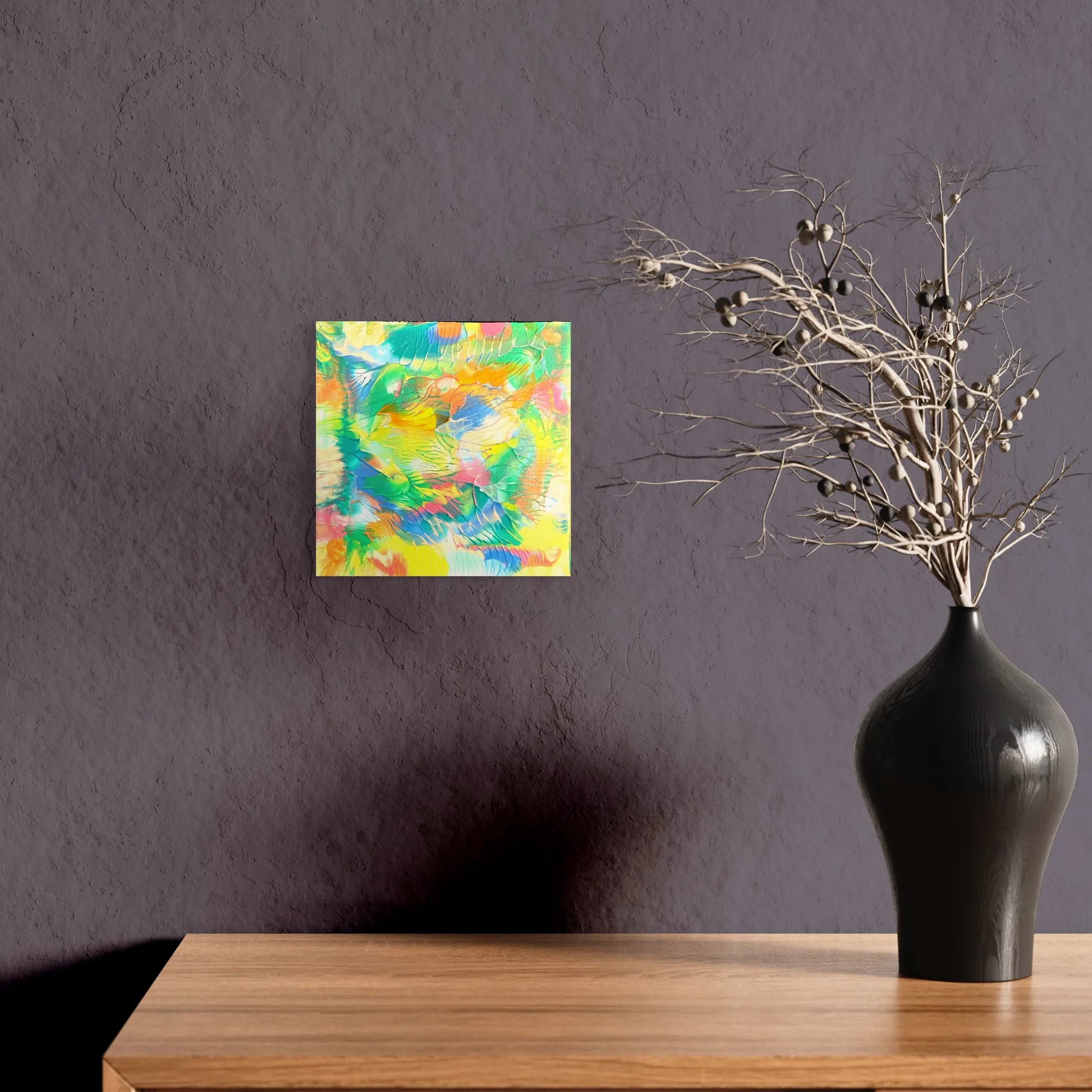 Vibrant abstract acrylic artwork featuring bright yellows, greens, and blues on a dark gray wall.