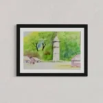 Watercolor view of a village with a church tower under bright green and yellow sky, in a black frame.
