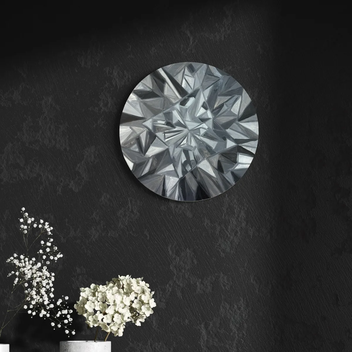 Silver geometric abstract artwork on a dark, textured background with white flowers below.