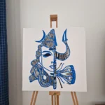 Blue and white acrylic artwork featuring a stylized, divine male face doodle.