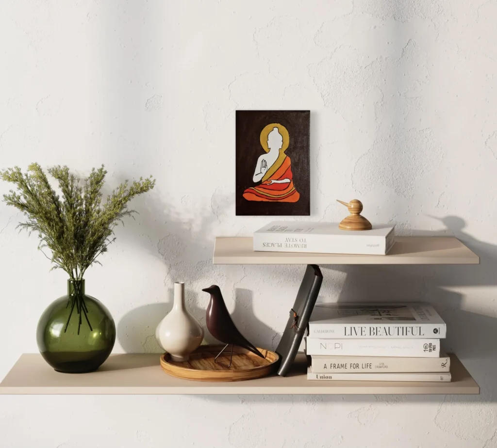 Seated Buddha figure in orange and white against a dark background, framed art.
